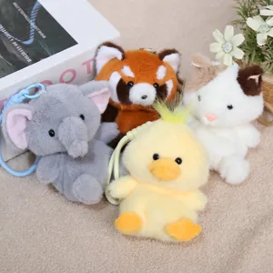 Primo piano di simpatici portachiavi di peluche di animali su morbido sfondo in tessuto.