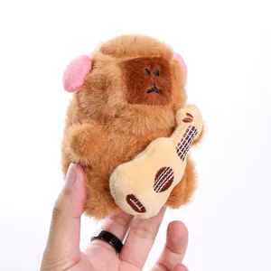 Detailed close-up of the cute musical capybara plush pendant holding a mini guitar toy.