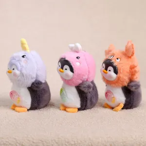 Primo piano dettagliato di simpatici portachiavi in peluche di pinguino con cappucci.