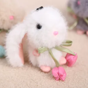 Simpatico portachiavi con coniglietto di peluche bianco, nastro verde e tulipano rosa.