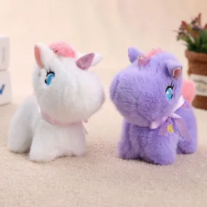 Detalle de llaveros de peluche de unicornio lindos en blanco y morado, colgante de bolso.