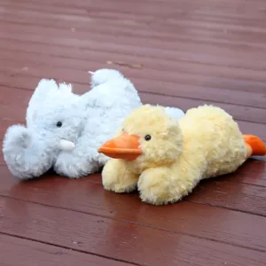 Detailed close-up of soft plush duck and elephant toys, cute lying stuffed animals.