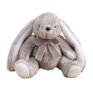 Mignon lapin en peluche aux longues oreilles assises avec nœud papillon à carreaux marron.