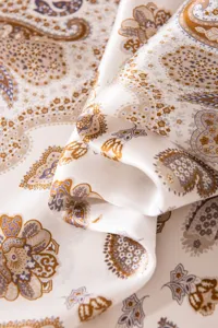 Silk scarf detail shot featuring elegant paisley print, lightweight mulberry silk fabric.