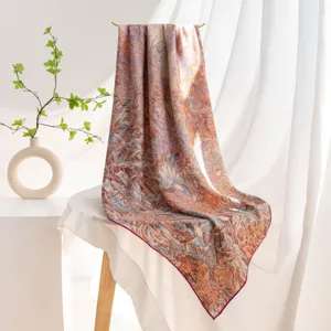 Gros plan sur le carré de foulard en soie et laine à imprimé floral, détail botanique élégant.