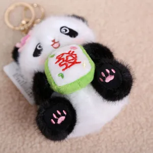 Close-up of cute panda plush keychain holding mahjong tile detail view fluffy texture bag charm