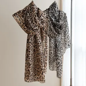 Close-up of lightweight leopard print scarves hanging, showing fine texture and color details.