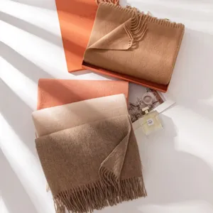 Accogliente sciarpa invernale in lana tinta unita con delicate frange. Dettaglio di qualità.