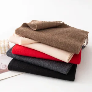 Stack of thick solid color winter cashmere scarves in multiple fashionable shades cozy and warm.