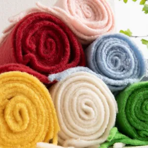 Vista dettagliata di sciarpe di lana unite e colorate arrotolate con una consistenza morbida.