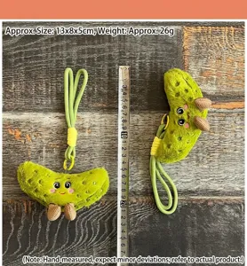 Cute green pickle plush toy keychain, funny fruit vegetable doll pendant with strap accessory.