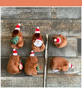 Vista detallada del lindo llavero de peluche de carpincho navideño, textura suave.
