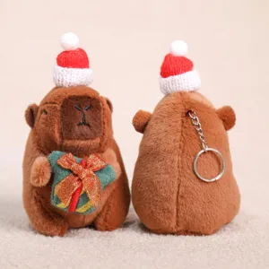 Vista detallada del llavero de peluche capibara lindo con gorro navideño y anillo de metal.