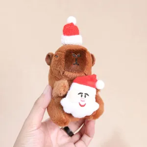 Primer plano del lindo colgante de felpa capibara de Navidad, decoración colgante de mochila.