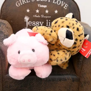 Set di peluche carino con un maialino rosa e un leopardo seduti su una piccola sedia.