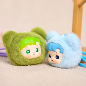 Gros plan détaillé du porte-clés poupée en peluche mignonne avec visage en vinyle et capuche.