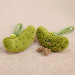 Close-up detail of cute green pickle plush toy keychain charm with soft fabric and sweet face.