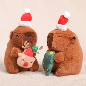 Primer plano de dos adorables peluches capibaras con gorros de Papá Noel y accesorios.