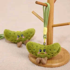 Cute plush pickle keychain detail, soft stuffed vegetable pendant with friendly smile for bags.