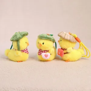 Detailed close-up of cute plush yellow duck keychains wearing lotus leaf hats and sweet scarves.