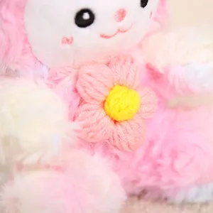 Close-up detail of fluffy pink tie-dye lamb plush toy showing soft texture and cute crochet flower.