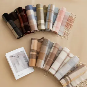 Detailed view of multiple rolled plaid cashmere scarves showcasing rich colors and soft texture.