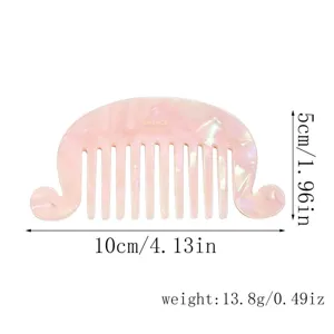 Pink acetate hair comb detail showing vintage wave edge tortoiseshell design and wide teeth, 10cm