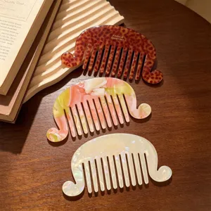 Detail view of French vintage acetate hair comb, wave edge design, elegant pearl finish.