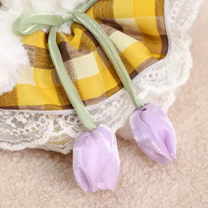 Plush toy doll clothing detail showing yellow plaid collar, lace trim and cute purple tulip ties.