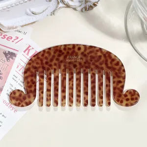 Detailed shot of tortoiseshell wide tooth hair comb, acetate vintage wave design detail.