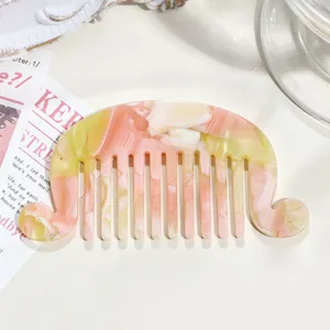 Close-up view of a French acetate hair comb featuring pearlescent pink and yellow marbled gradient design.