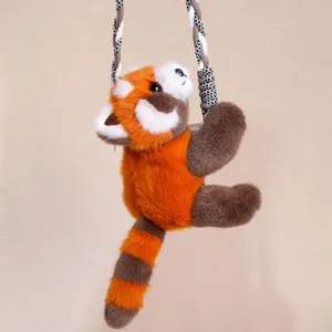 Close-up detail view of the cute red panda plush toy hanging on a woven rope, soft fur texture.