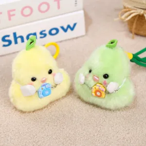 Close-up detail of cute pear duck plush keychain with miniature camera pendant, soft toy.