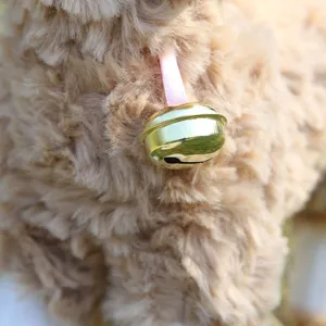Close-up detail of the cute plush sheep toy featuring a soft camel fleece and a golden bell.