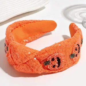 Detailed view of the orange sequin knotted headband with beaded Halloween pumpkin design.