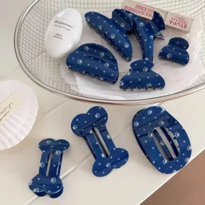 Close-up detail of blue star and paw print hair claws, bone shaped clips in a wire basket.