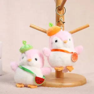 Portachiavi pinguino in peluche carino con cappello e borsa di frutta, dettaglio bambola morbida.