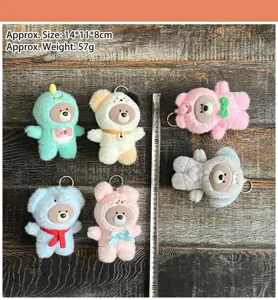 Close-up detail view of cute animal transformation plush toy pendants with vinyl faces and metal keyrings.