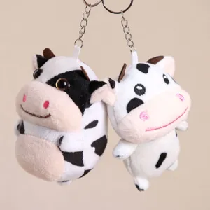 Vista dettagliata del portachiavi in peluche di mucca bianco e nero, ciondolo borsa.