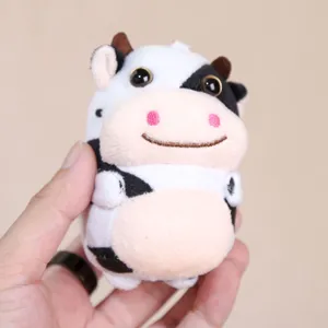 Primo piano dettaglio di simpatico ciondolo in peluche di mucca bianco e nero, morbido portachiavi soffice.
