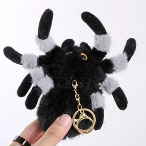 Fluffy spider plush pendant detail showing soft black and gray fur with golden keyring hardware.