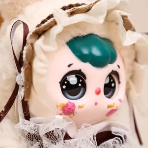 Primer plano del colgante de muñeca de vinilo de peluche con capucha de encaje y ojos brillantes.