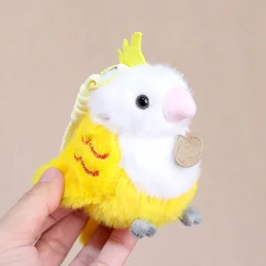 Close up detail of cute yellow and white bird plush toy pendant with soft fluffy texture.