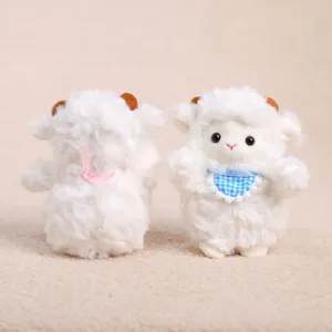 Plush sheep pendant detail view showing fluffy white texture, blue bib and pink bow ribbon.