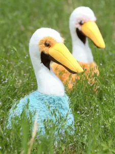 Cute pelican plush toy detailed close-up showing soft blue and orange fabric texture outdoors.