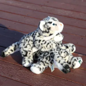 Primer plano de bonito juguete de peluche de leopardo de las nieves, textura suave, tumbado.