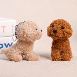 Cute plush poodle dog keychain detail shot, soft fluffy couple hanging toy bag accessory.