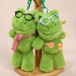 Primer plano detallado de dos simpáticos llaveros de rana de peluche verde con gafas.