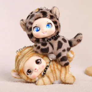 Close-up detail of cute plush doll keychains with vinyl face and animal print hoods for bags.