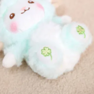 Gros plan détaillé d'un adorable pendentif mouton en peluche verte avec broderie de trèfle.